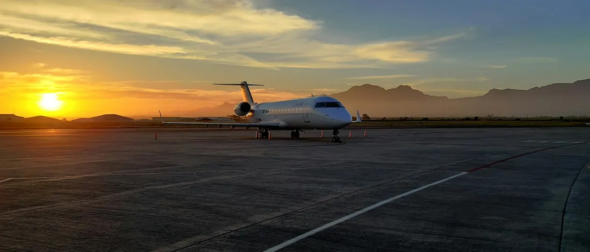 Business jet on an empty ramp as the sun sets behind hills